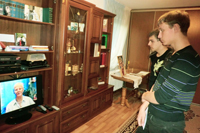Посетители музея смотрят телепередачу Гордость России, посвященную Зое Куприяновой
